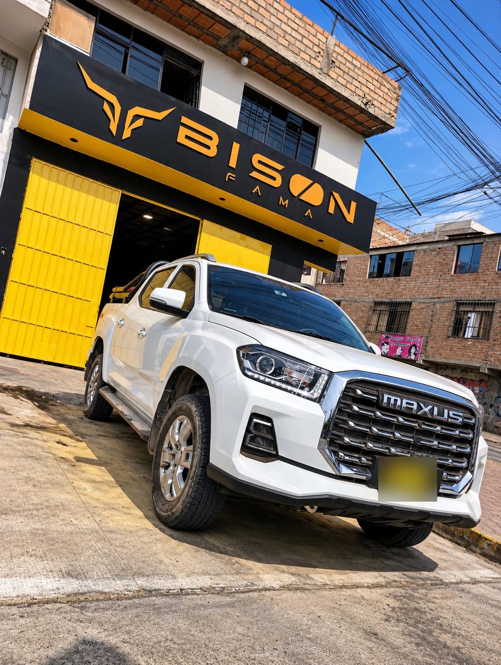 Fachada del local de BISON FAMA en el Callao con una pickup blanca estacionada